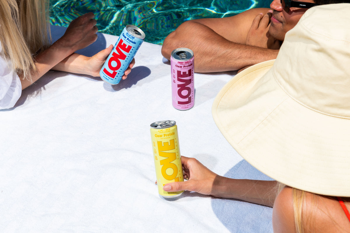 Friends enjoying LOVE clear protein cans poolside